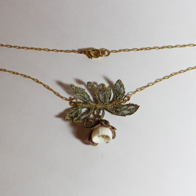 collier porcelaine une clochette entourée de de clochette en broderie sur organza et feuilles en broderie couleur vert foncé, doré, sur chainette dorée